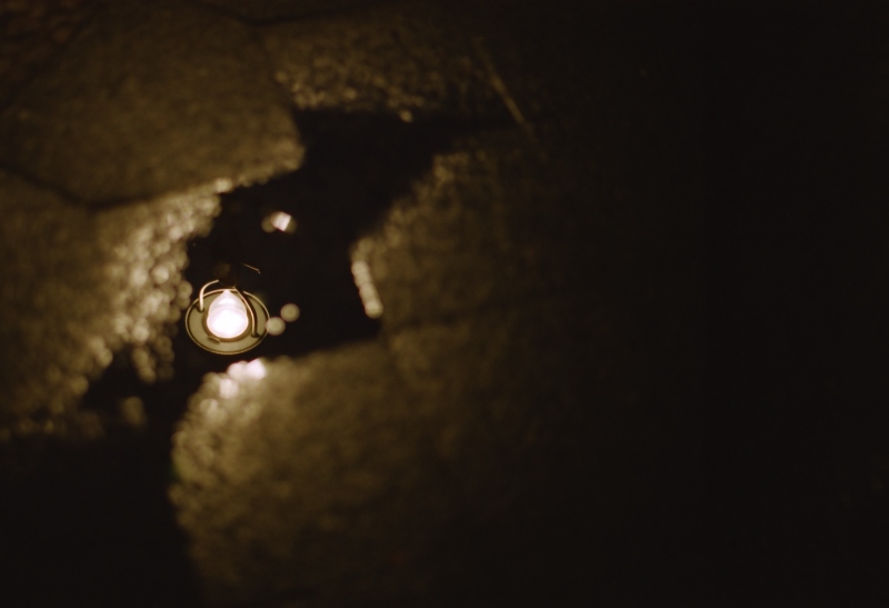 Spiegelung einer Lampe in einer Pfütze